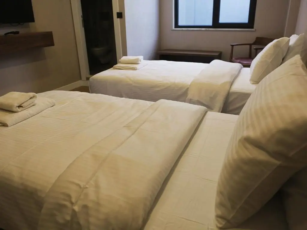 Twin Room: close-up of the beds, the bathroom door and television