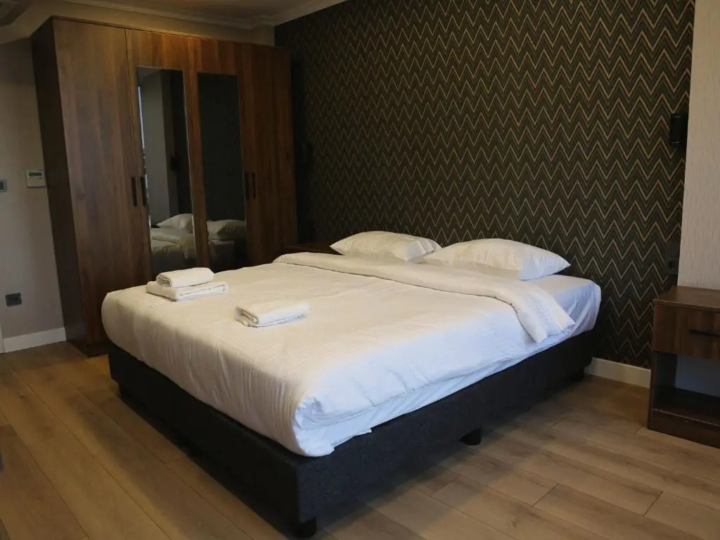 Double Room: bed, zigzag wallpaper and mirrored wardrobe