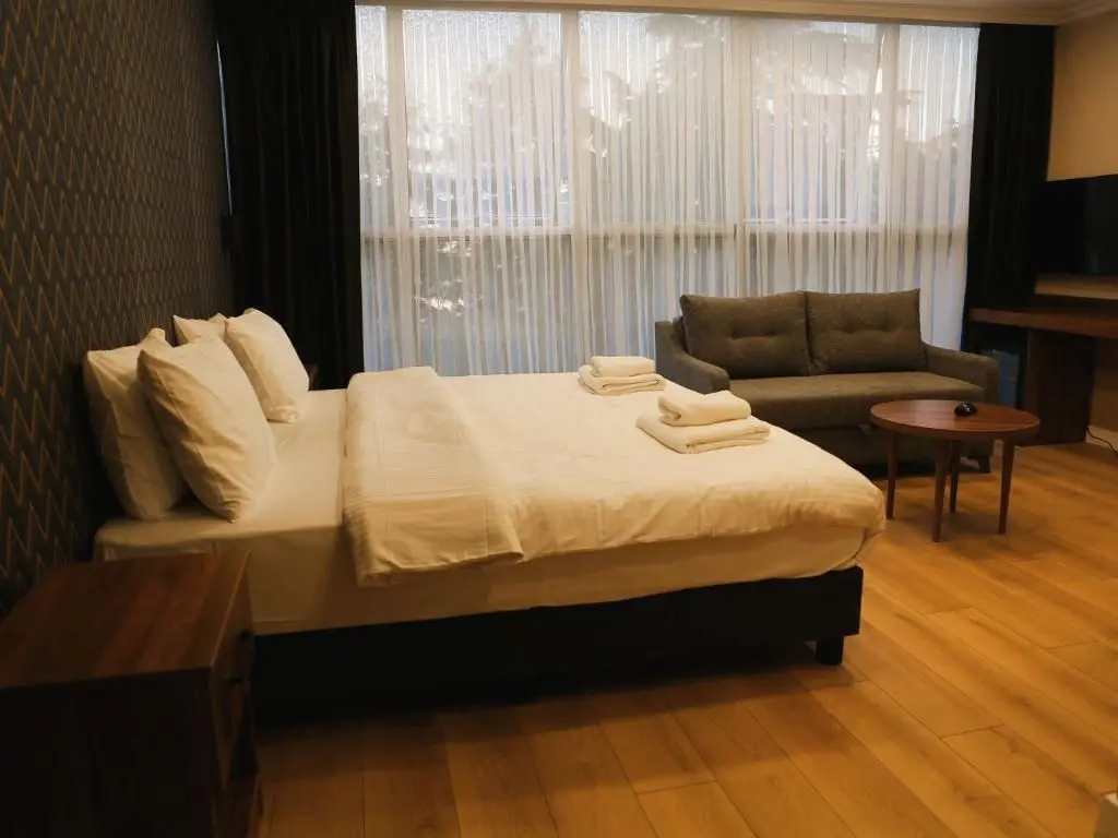 Double Room: bed, grey sofa and round table