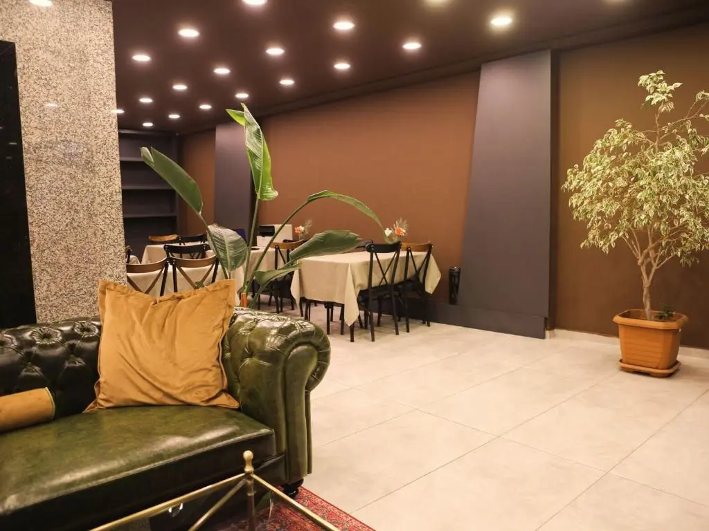 Lobinin arkasındaki salon: örtülü masalar ve ahşap sandalyeler