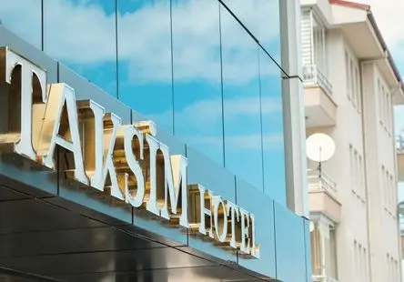 Otel tabelası: cam cephede altın rengi “Taksim Hotel” harfleri